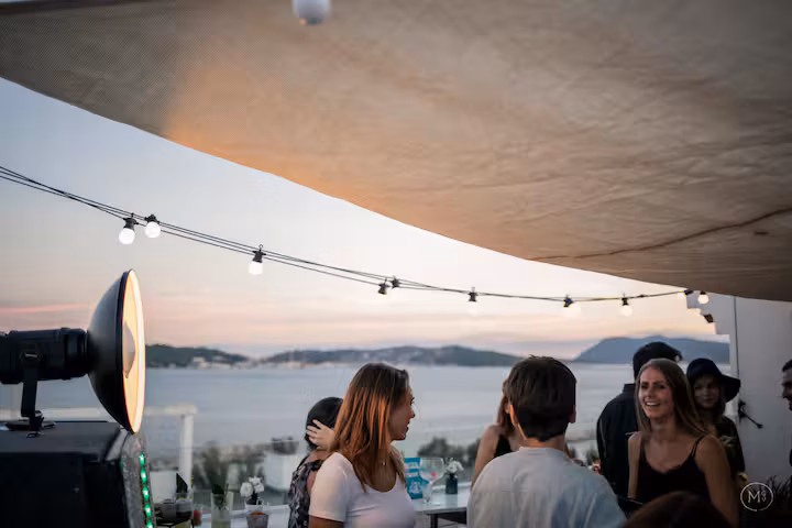 The fourth-floor rooftop at sunset, string lights and a view over the bay